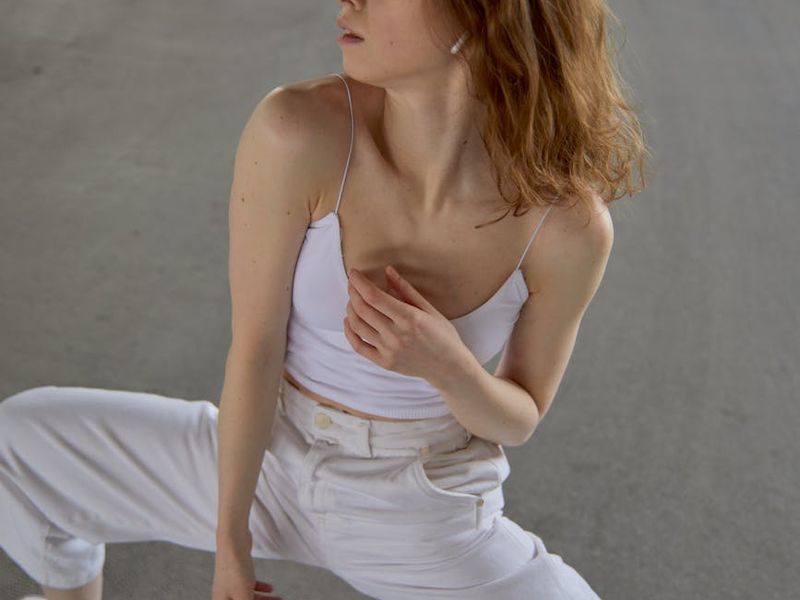 A person performing a slow, controlled movement in a calm studio.